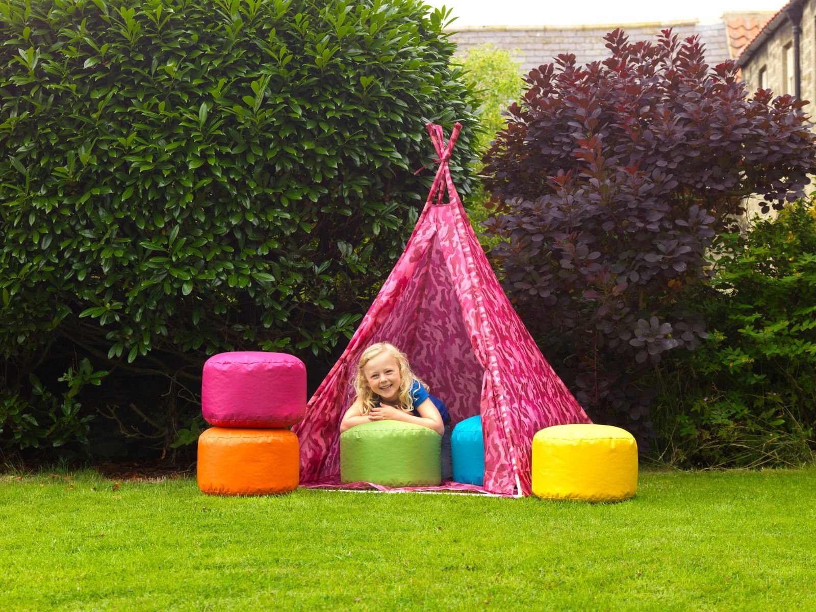 Girl playing with kids bean filled pods in garden