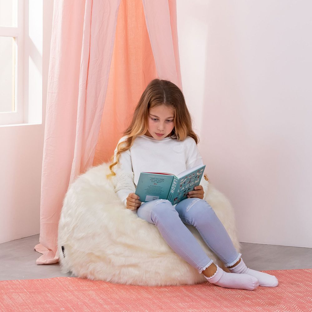 icon® Luxury Faux Fur Kids Classic Bean Bag in cream with model